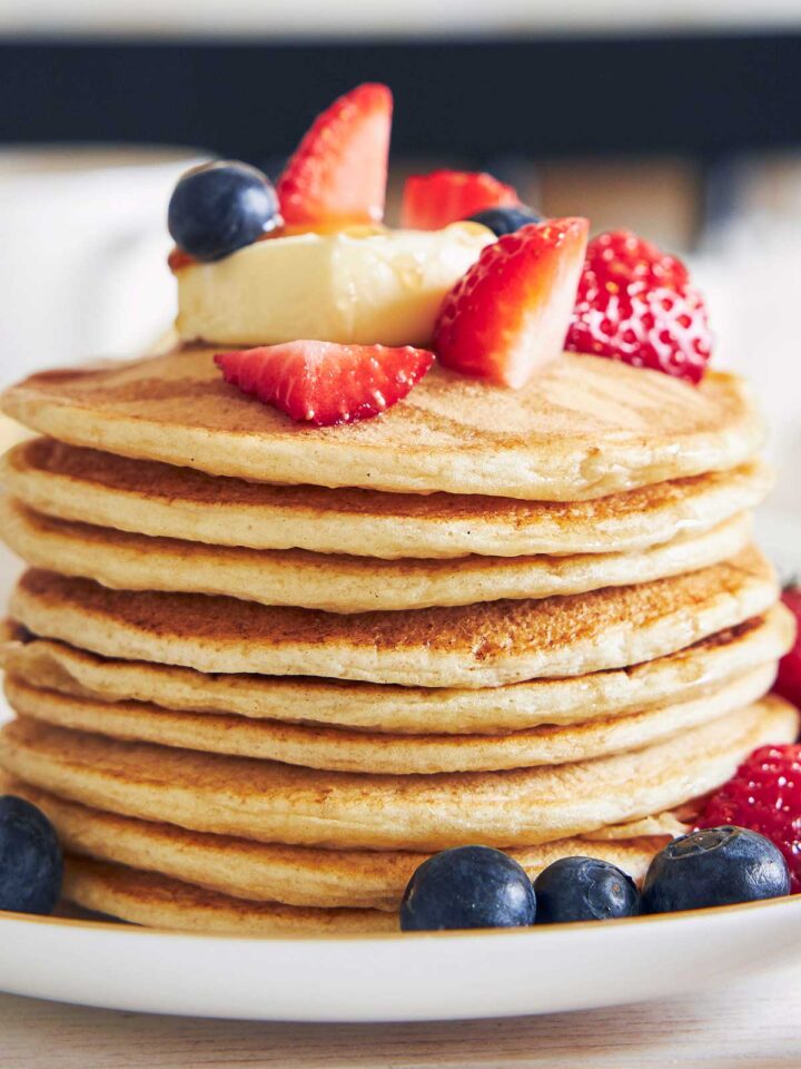 una pila de tortitas de queso cottage con frutos rojos por encima