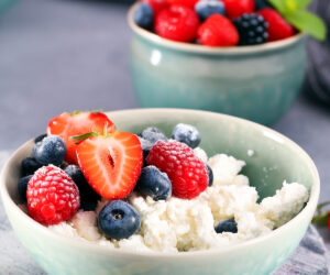 bol con queso cottage y frutas y otro bol más pequeño detrás con bayas