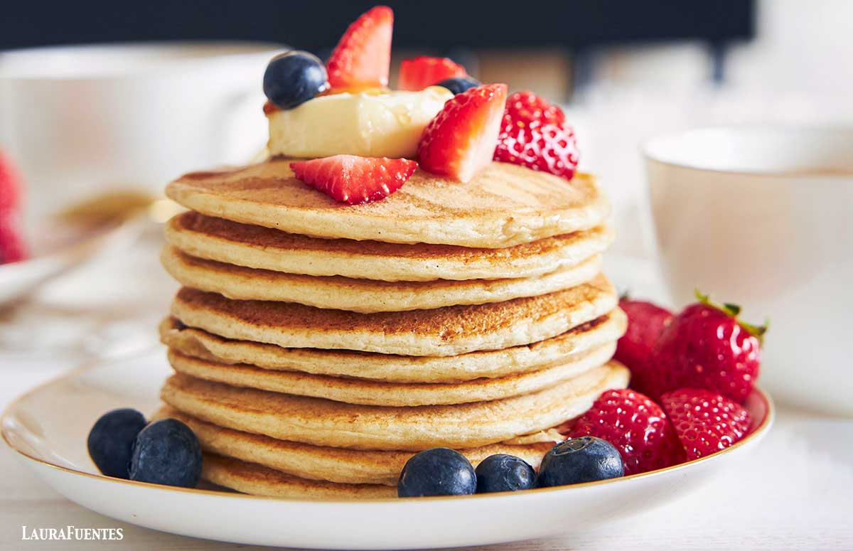 una pila de tortitas de queso cottage con frutos rojos por encima
