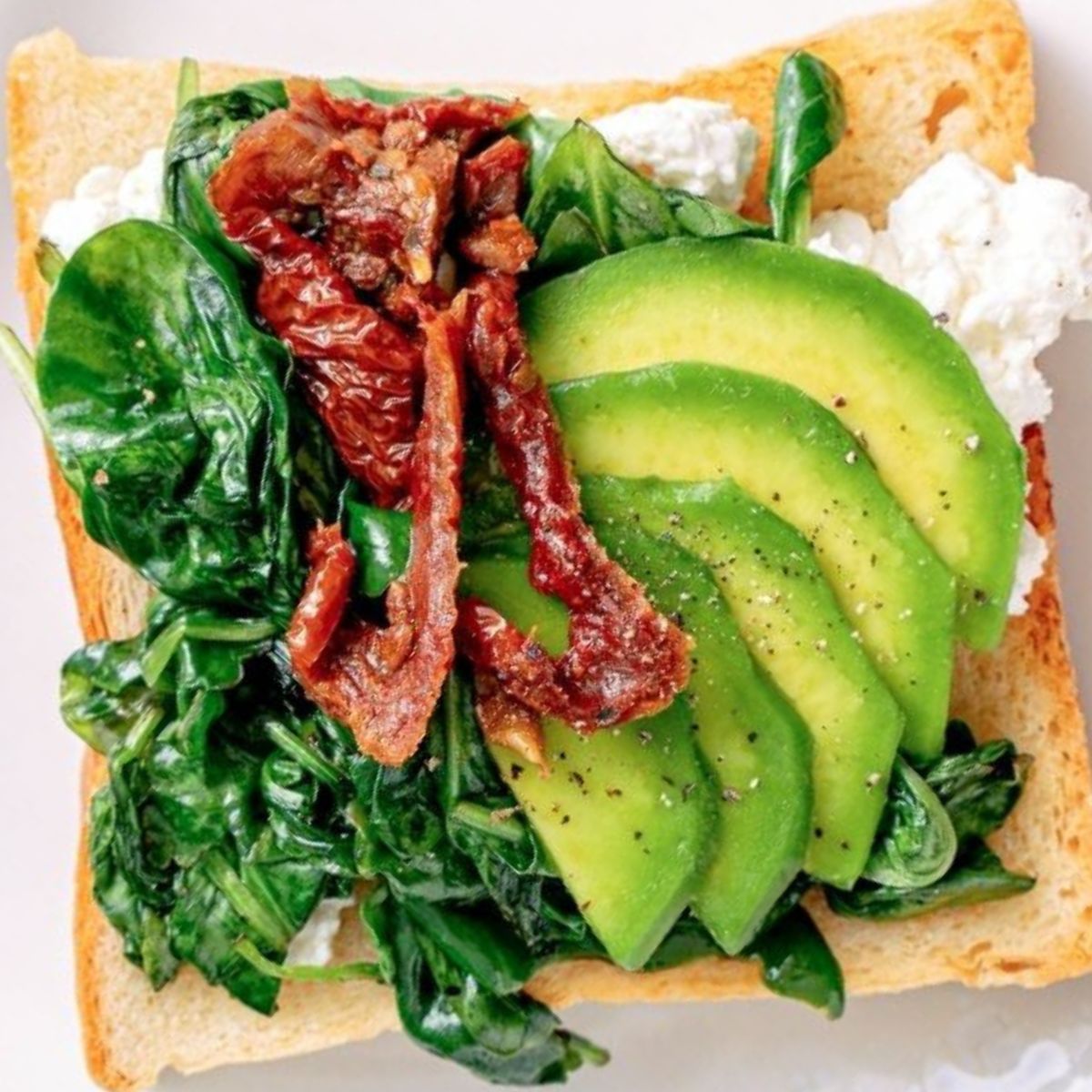 tostada con queso cottage, aguacate, bacon y verduras verdes